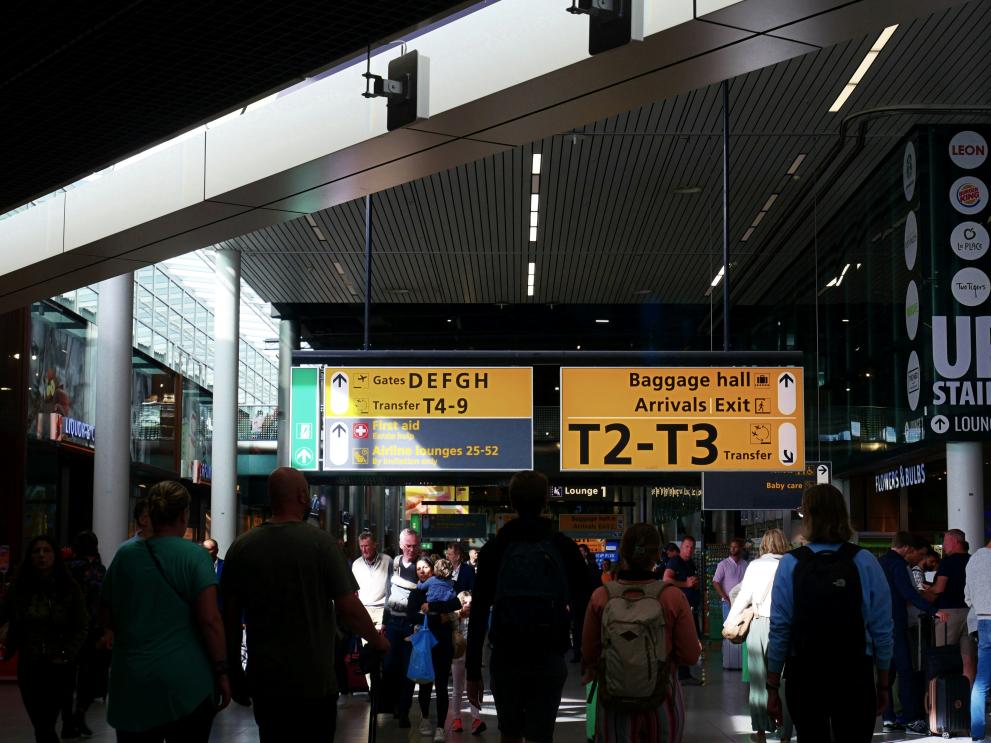 inside an airport terminal showing signs for the gates